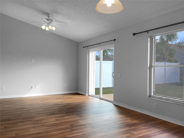 unfurnished room with a ceiling fan, wood finished floors, baseboards, lofted ceiling, and a textured ceiling