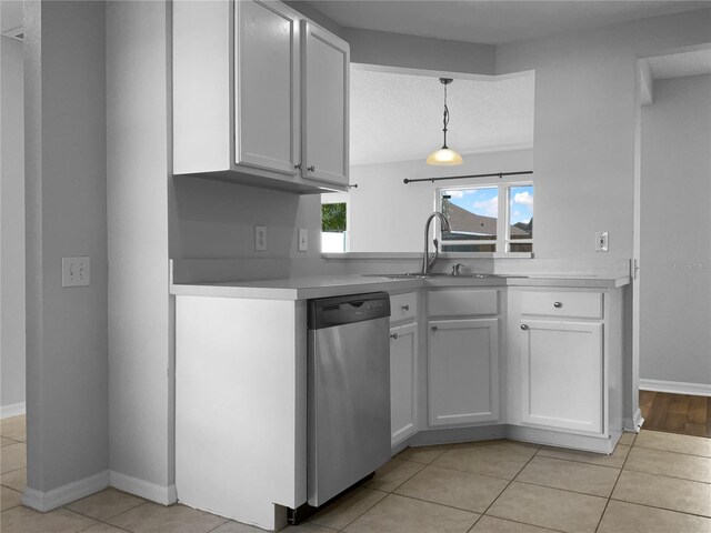 kitchen featuring light tile patterned flooring, dishwasher, light countertops, and a sink