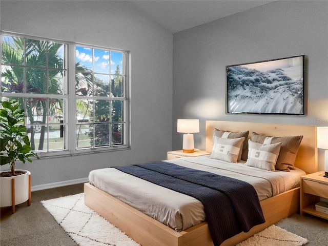 bedroom with carpet flooring, baseboards, and lofted ceiling