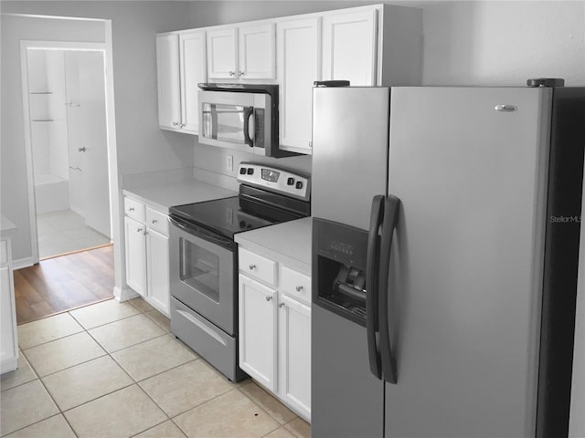 kitchen featuring light tile patterned floors, white cabinets, stainless steel appliances, and light countertops