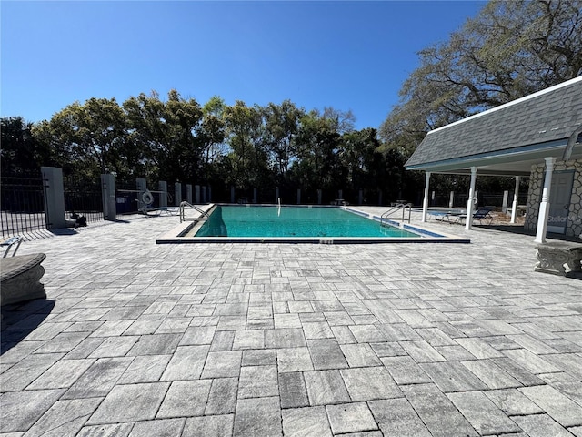 community pool featuring a patio area and fence