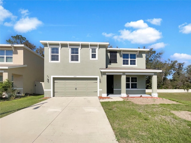 traditional-style house with a front yard, driveway, an attached garage, covered porch, and stucco siding