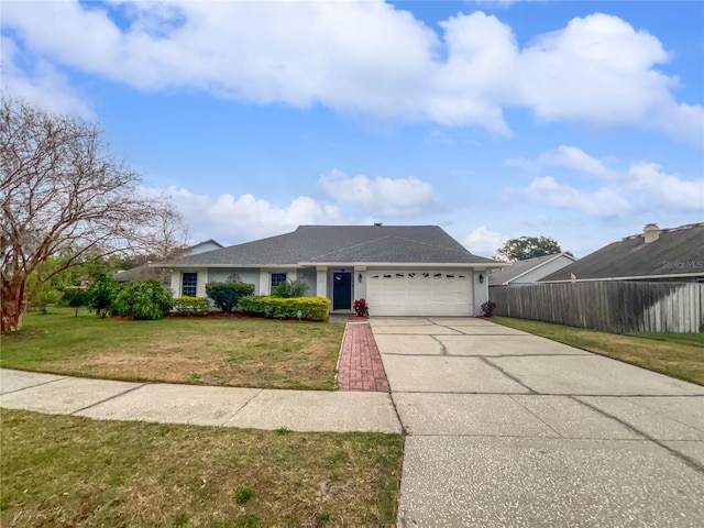 view of front of home with a front yard, fence, driveway, an attached garage, and stucco siding