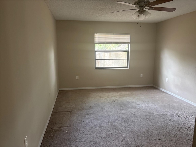 carpeted empty room with baseboards, a textured ceiling, and a ceiling fan