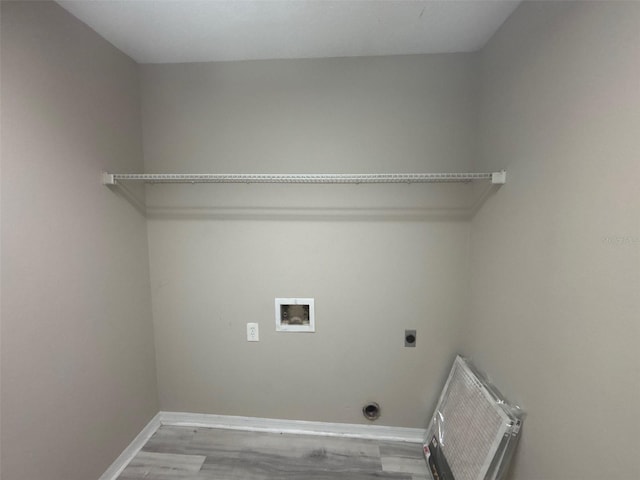 washroom featuring wood finished floors, baseboards, hookup for an electric dryer, hookup for a washing machine, and laundry area