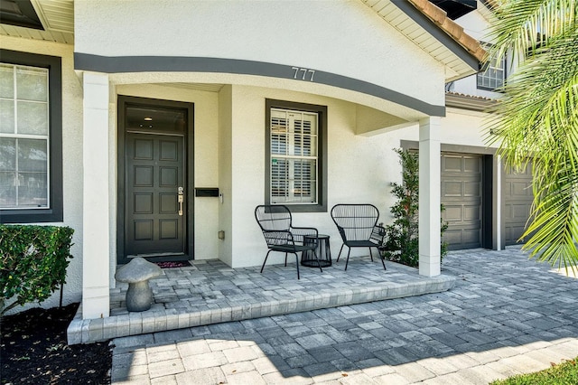 property entrance with stucco siding and a porch