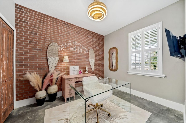 office space featuring baseboards, concrete floors, and brick wall