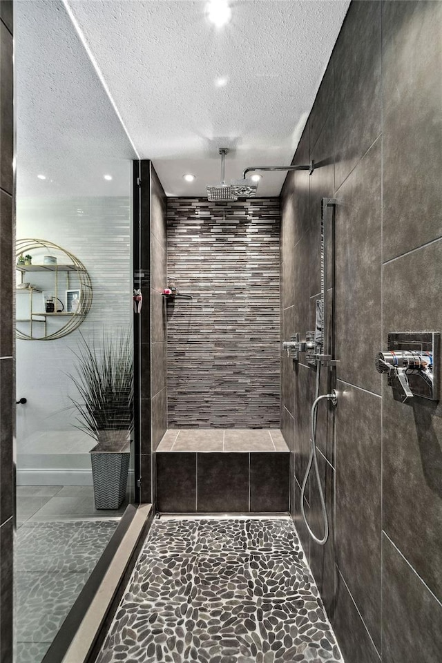 bathroom with tiled shower and a textured ceiling