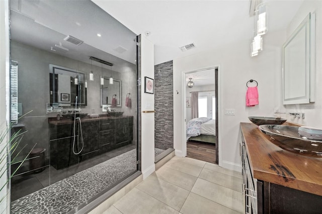 bathroom featuring double vanity, visible vents, connected bathroom, and a stall shower