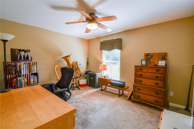 carpeted office featuring baseboards and ceiling fan