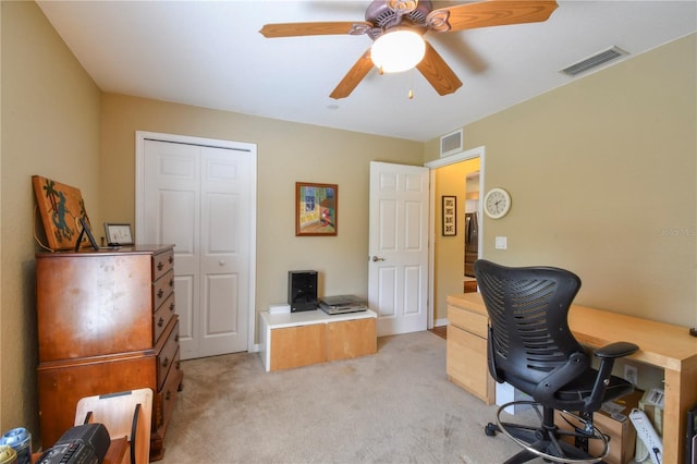 home office with light carpet, visible vents, and ceiling fan