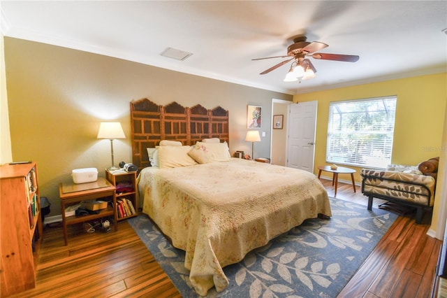 bedroom featuring dark wood-type flooring, crown molding, and baseboards