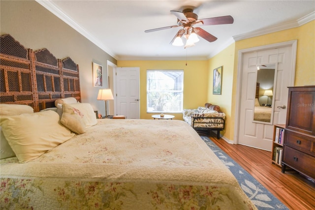 bedroom with baseboards, a ceiling fan, wood finished floors, and crown molding