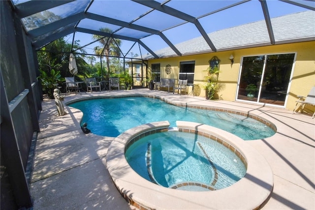 view of swimming pool with a patio area, a lanai, and a pool with connected hot tub