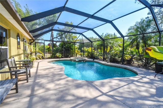 view of swimming pool with a patio area, glass enclosure, and a pool with connected hot tub