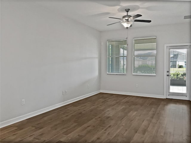 unfurnished room with visible vents, baseboards, dark wood finished floors, and a ceiling fan