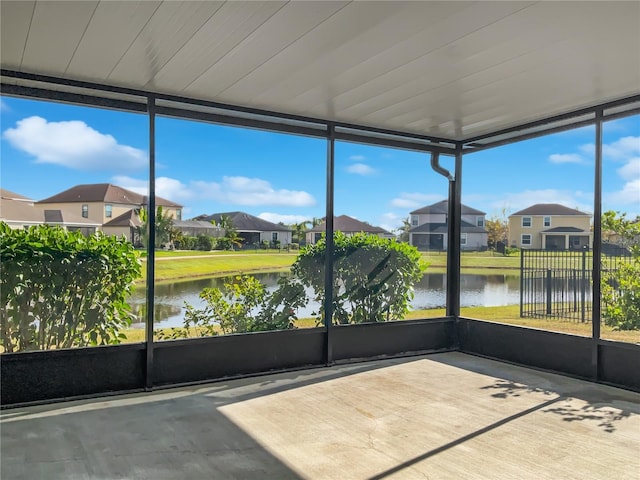 unfurnished sunroom with a water view and a residential view