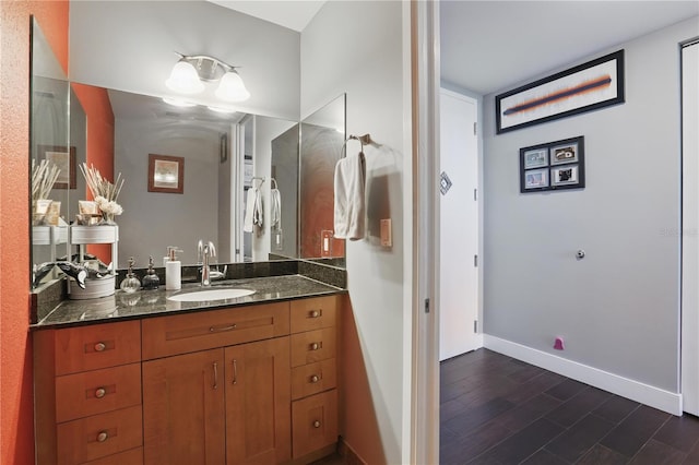 bathroom with vanity, wood finished floors, and baseboards