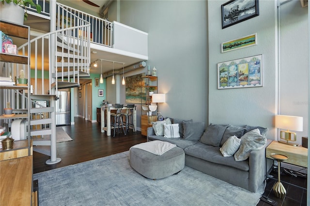 living room featuring wood finished floors, baseboards, and a towering ceiling