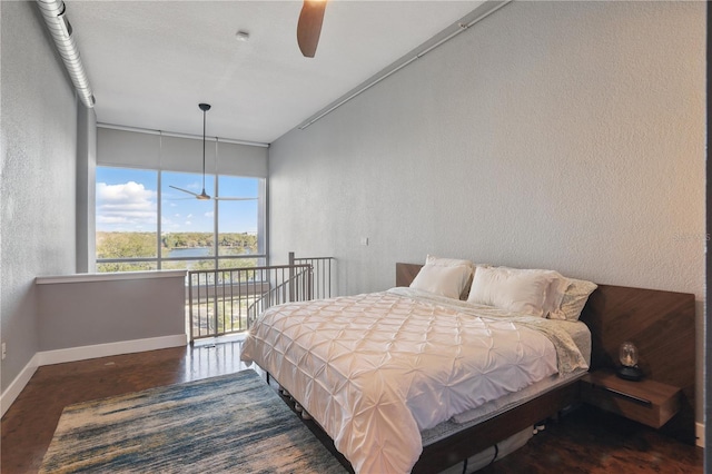 bedroom with access to exterior, ceiling fan, baseboards, and a textured wall