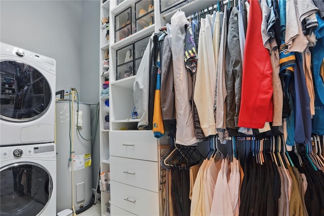 laundry area with water heater, laundry area, and stacked washer and dryer