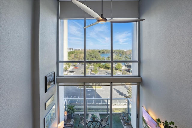 details with a water view, ceiling fan, and a textured wall