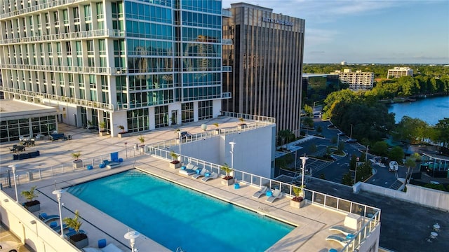 pool featuring a patio and a water view