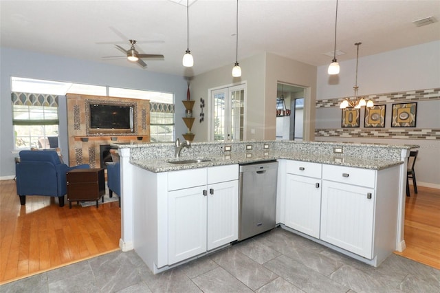 kitchen with a ceiling fan, visible vents, a sink, stainless steel dishwasher, and open floor plan