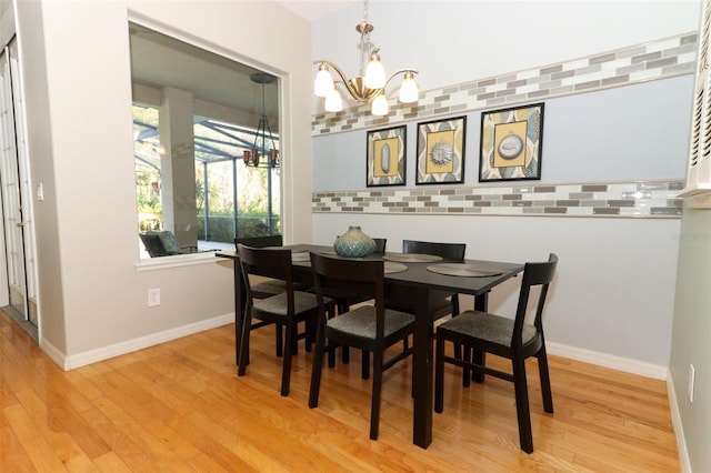 dining area with an inviting chandelier, wood finished floors, and baseboards