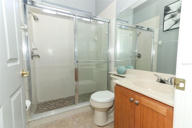 bathroom featuring tile patterned floors, toilet, a stall shower, and vanity