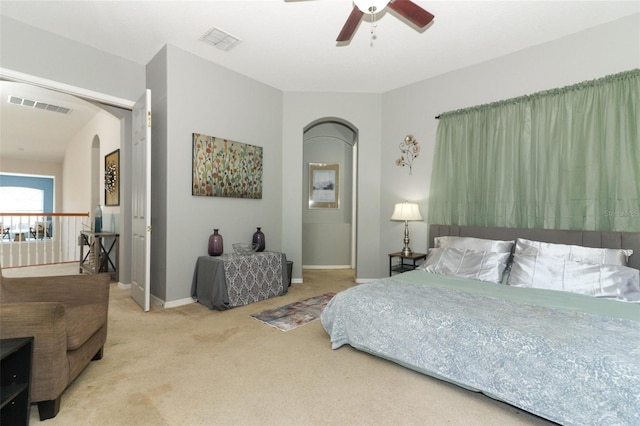 bedroom with arched walkways, visible vents, baseboards, and carpet