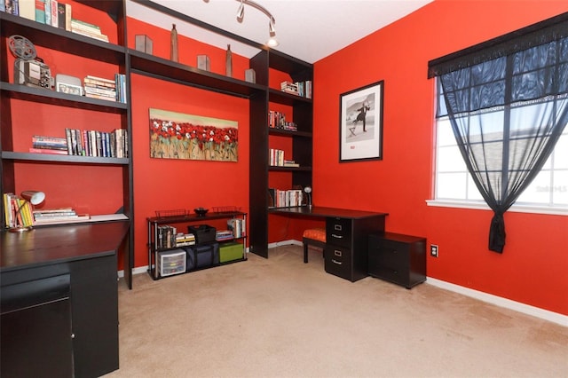 carpeted home office featuring built in features and baseboards