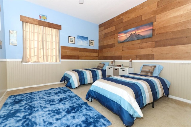 bedroom featuring wooden walls and carpet