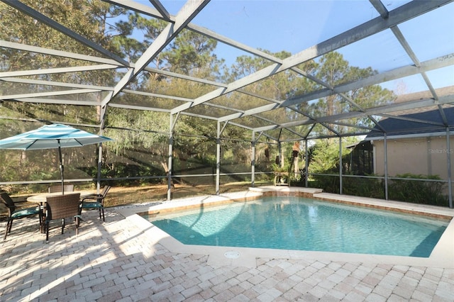 outdoor pool featuring outdoor dining space, glass enclosure, and a patio