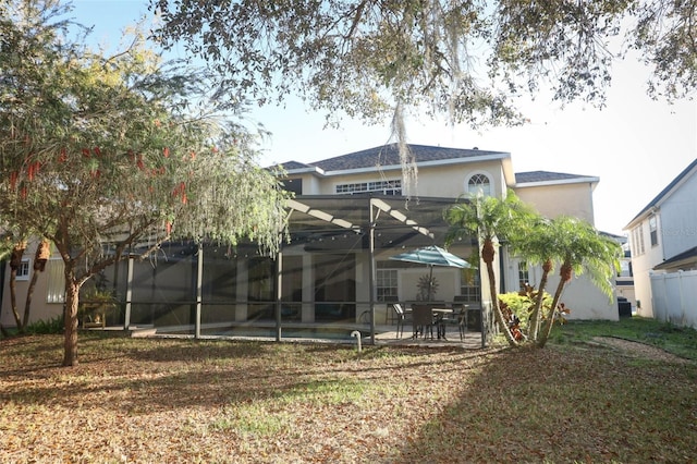 back of property featuring a lanai, a patio area, and stucco siding