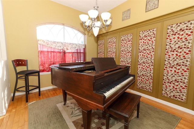 sitting room featuring baseboards, wood finished floors, and a chandelier