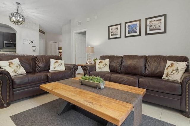 living area featuring visible vents, arched walkways, and light tile patterned flooring