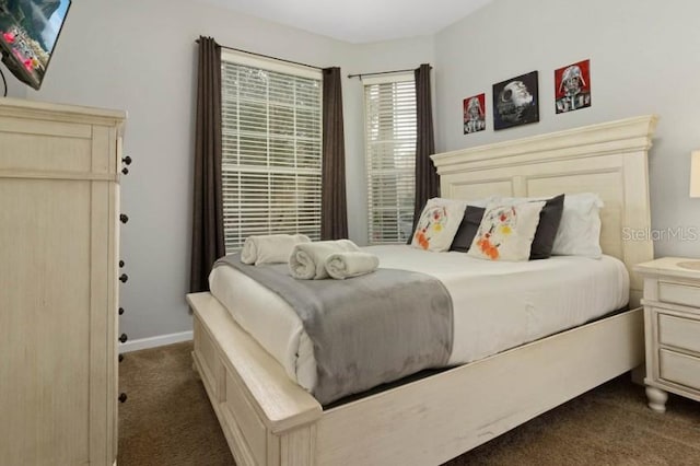 bedroom with baseboards and dark carpet