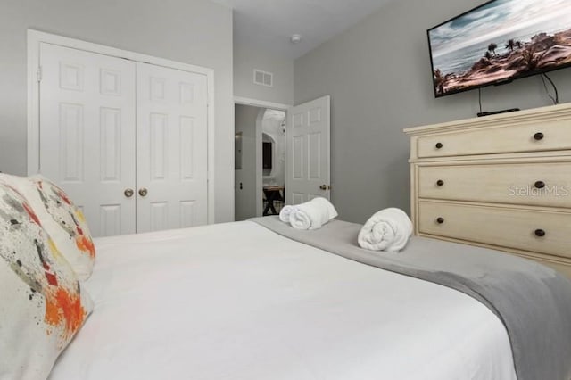 bedroom featuring arched walkways, visible vents, and a closet