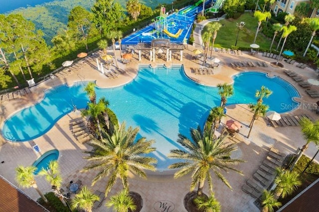 pool featuring a patio area, fence, and a water slide