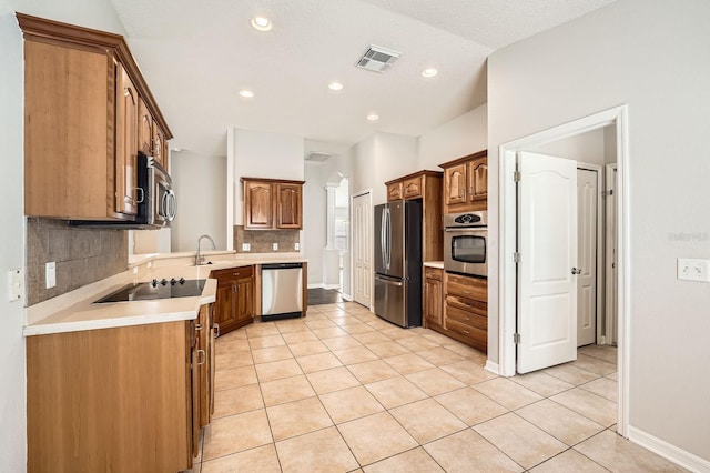 kitchen featuring light tile patterned flooring, visible vents, appliances with stainless steel finishes, and decorative backsplash