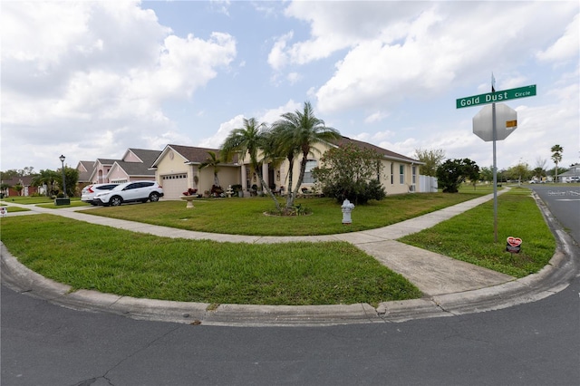 view of front of property with a front lawn, an attached garage, a residential view, and driveway