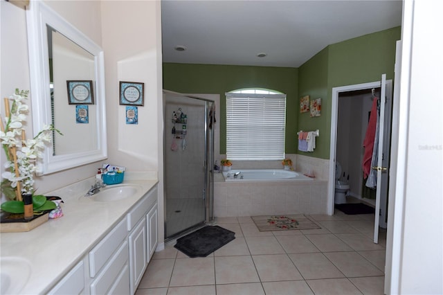 bathroom featuring a sink, toilet, a stall shower, and tile patterned flooring