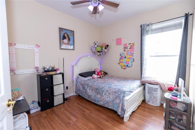 bedroom featuring light wood-style flooring, a ceiling fan, and baseboards