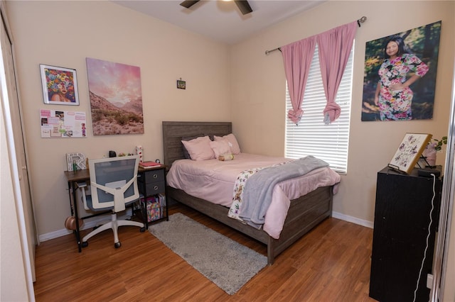 bedroom featuring ceiling fan, baseboards, and wood finished floors