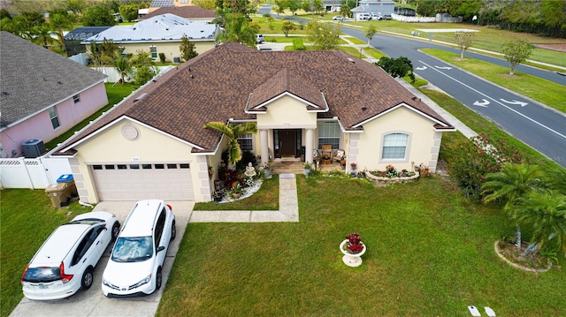 ranch-style house featuring stucco siding, a front lawn, driveway, fence, and an attached garage