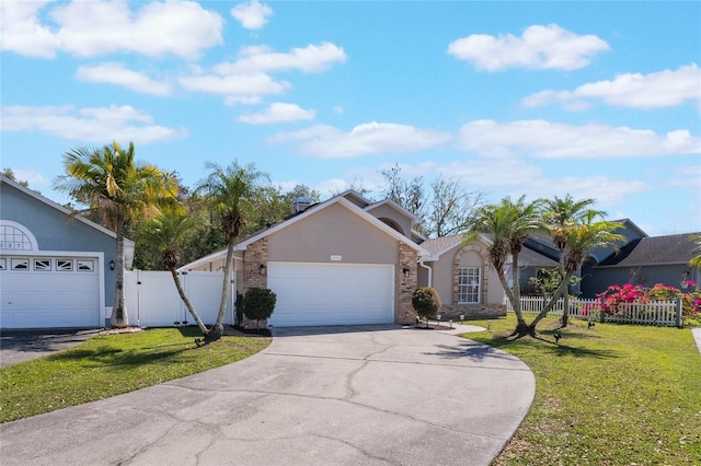 ranch-style house with a front lawn, fence, stucco siding, driveway, and a gate