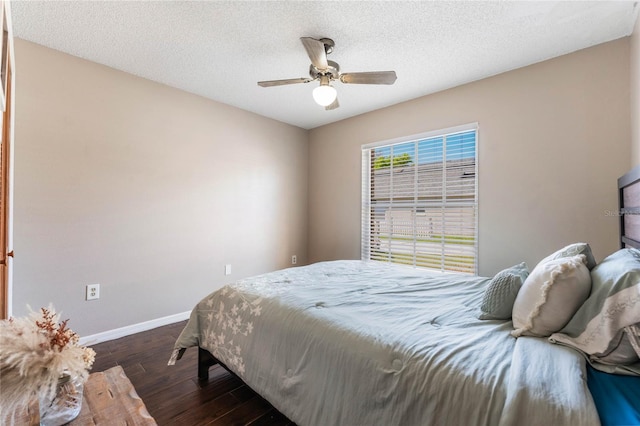 bedroom with baseboards, a textured ceiling, wood finished floors, and a ceiling fan