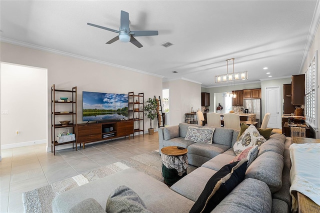 living room featuring light tile patterned floors, baseboards, visible vents, ornamental molding, and ceiling fan with notable chandelier