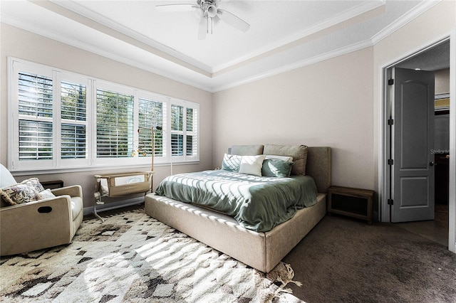 bedroom with carpet flooring, a raised ceiling, ceiling fan, and crown molding